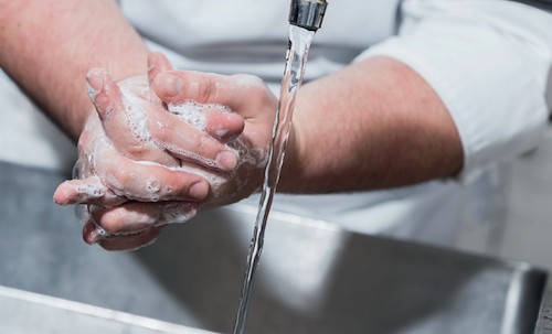 Person die sich die Hände wäscht